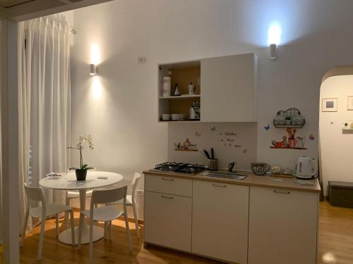 una cucina con tavolo e tavolo e sedie bianchi di Papu's House a Salerno