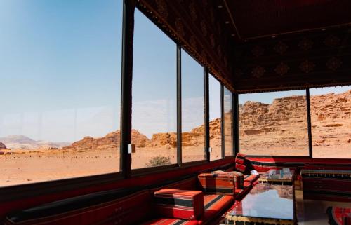 a room with a view of the desert through windows at Wadi Rum Travel camp in Wadi Rum