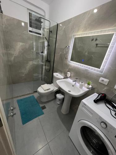 TERRACE VIEW APARTMENTS في سارنده: حمام مع حوض استحمام وغسالة ملابس