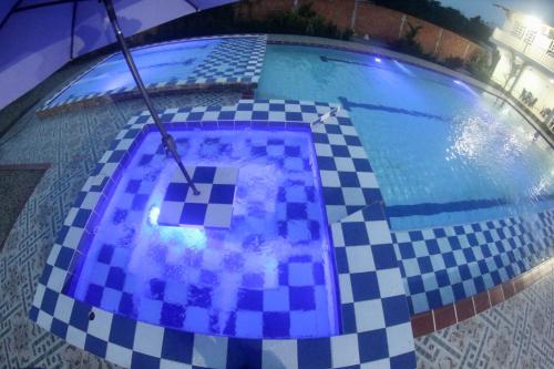 a pool with a checkered floor and an umbrella at BAHIA MALECON in Acacías