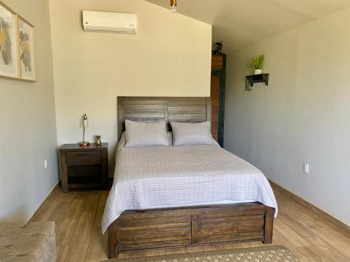a bedroom with a large bed with a wooden headboard at Coquenas del Valle in Valle de Guadalupe