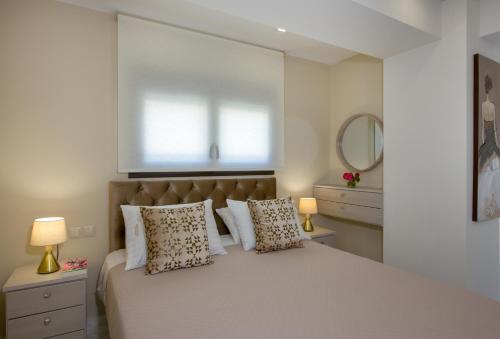 une chambre avec un grand lit avec des oreillers et une fenêtre dans l'établissement Aretousa Home, à La Canée