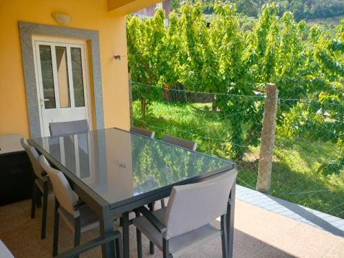 a table and chairs with a view of a vineyard at Vineyards Valley House in Penajoia