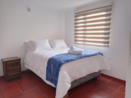 - une chambre avec un lit blanc et une fenêtre dans l'établissement Villa del Prado, à Villa de Leyva