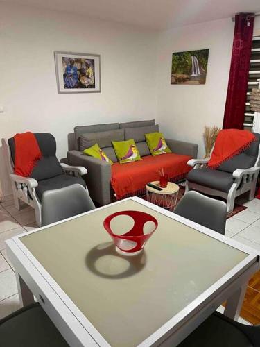 a living room with a table with a red vase on it at Villa Saint-Paul in Pointe-Noire