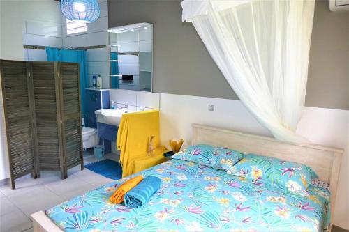 a bedroom with a bed and a bathroom with a sink at Villa Saint-Paul in Pointe-Noire