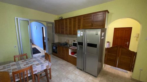 uma cozinha com um frigorífico de aço inoxidável e armários de madeira em Apartman Down Town em Sremska Mitrovica
