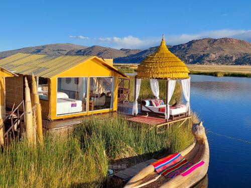 a house on the water with a boat in the water at Uros Lodge Perú in Puno