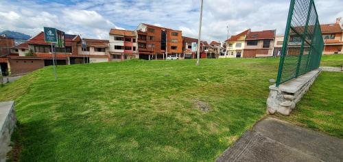 a grassy field with a basketball hoop in a city at Departamento en Cuenca, 3 Habitaciones y parqueo gratis in Cuenca
