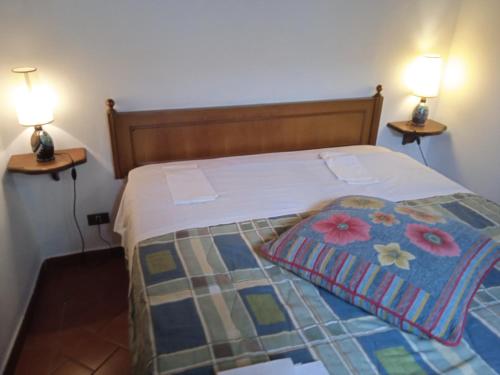 um quarto com uma cama com 2 candeeiros em ambos os lados em La casa di Daisy em Pitigliano