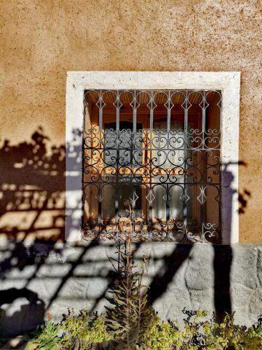 a window with a iron gate on a building at Maison d'hôte tamatart - Homestay in Kalaat MGouna