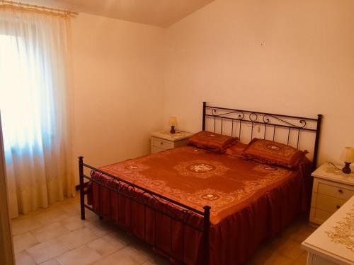 um quarto com uma cama com uma colcha vermelha e uma janela em Mo.Da' Apartments em San Marino