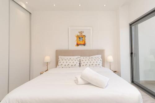 Un dormitorio blanco con una cama blanca y una ventana en Luxe Dream Villa en Charneca