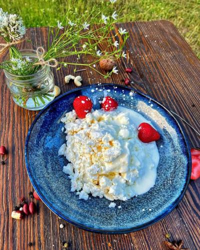 a blue plate of food with strawberries on a table at Садиба Бабина Лоза in Lisove