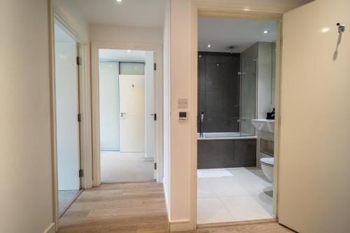 a bathroom with a toilet and a sink and a tub at Luxury 2-Bed Croydon Apartment Near Gatwick in Croydon