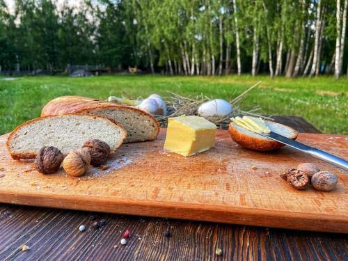 a cutting board with bread and cheese on a table at Садиба Бабина Лоза in Lisove