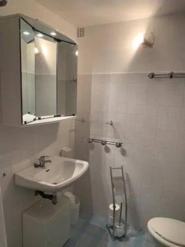 une salle de bain avec un lavabo, des toilettes et un miroir dans l'établissement Beau T2 entre Santa Giulia et Palombaggia -, à Porto-Vecchio