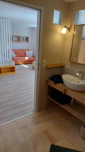 a bathroom with a sink and a living room at Apartment Fritali in Tadten