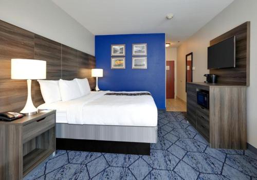 a bedroom with a large bed and a blue wall at La Quinta by Wyndham Denton - University Drive in Denton
