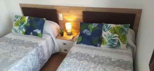 a bedroom with two beds and a table with a lamp at PISO NAVAS 2 in Navas de San Antonio