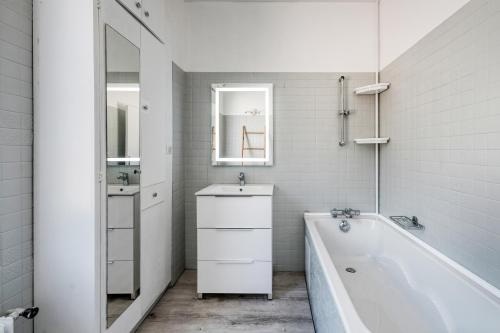 a white bathroom with a tub and a sink at Magnifique maison pleine de charme ideale jeux olympiques un kilometre de la gare in Évreux