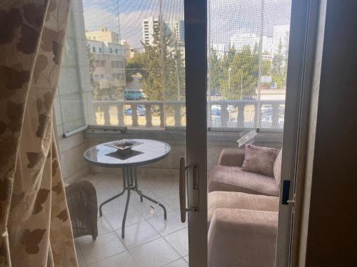 a balcony with a table and a couch and a window at Zagha house in Amman