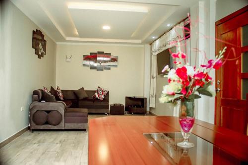sala de estar con sofá y mesa con flores en Casa de Campo - Baños de Agua Santa, en Juivi