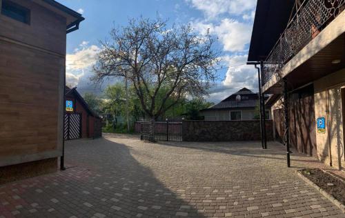 a brick courtyard with a fence and a tree at Cottage 'Carolina' with hot tub, sauna and BBQ area in Kosiv