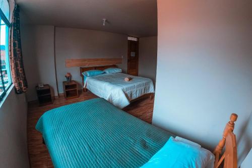 a bedroom with two beds and a window at Chacraraju Hostel in Huaraz