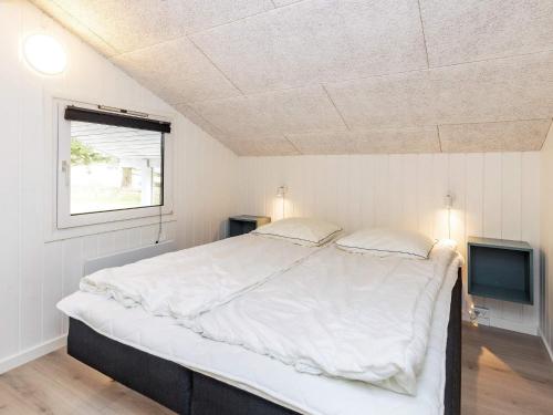 a bedroom with a large bed and a television at Holiday Home Falkevej IV in Terpet