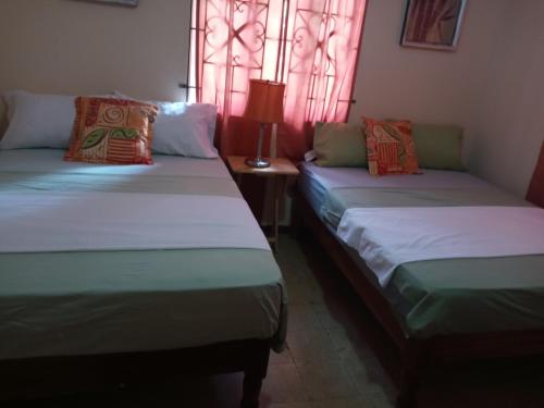 dwa łóżka siedzące obok siebie w pokoju w obiekcie Twin Court Retreat w mieście Port Antonio