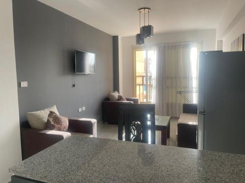 加利卜港的住宿－Marina City portghalib one bedroom，厨房以及带冰箱和沙发的客厅。