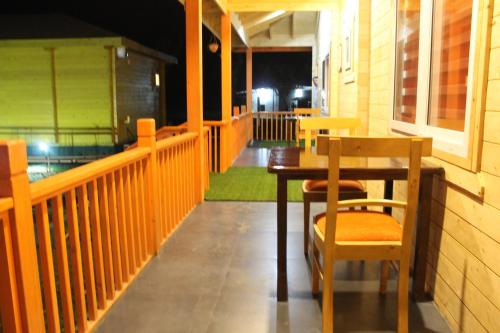 einen Tisch und Stühle auf der Veranda eines Restaurants in der Unterkunft The Laughing Woods in Kotagiri