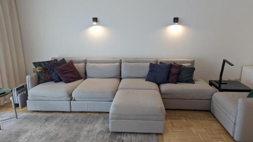 ein Wohnzimmer mit einer weißen Couch mit bunten Kissen in der Unterkunft Central apartment with terrace in Knokke in Knokke-Heist