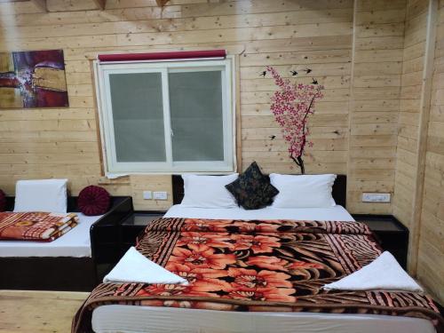 een slaapkamer met 2 bedden en een raam bij The Laughing Woods in Kotagiri
