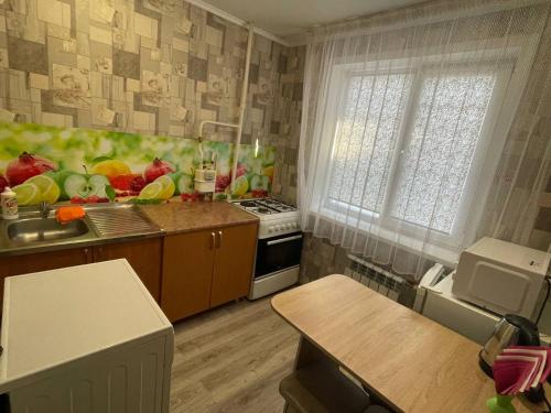 cocina con fregadero y fogones en Отличная 1-комнатная квартира в центре! Standart, en Petropavlovsk