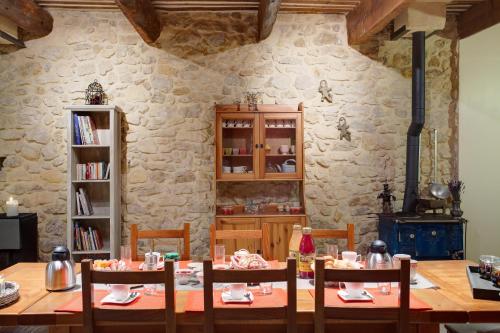 une salle à manger avec une table et un mur en pierre dans l'établissement La Ferme Du Midi, à Piolenc