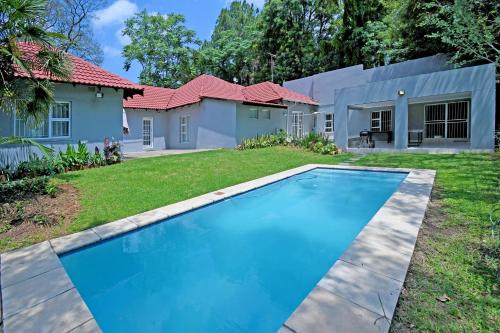 uma casa com piscina em frente a um quintal em Zwelakho Furnished Apartments The Cube em Joanesburgo