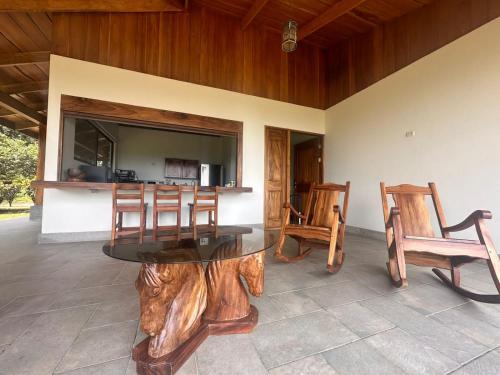 uma sala de jantar com uma mesa e cadeiras de madeira em Casa areno lodge em Bijagua