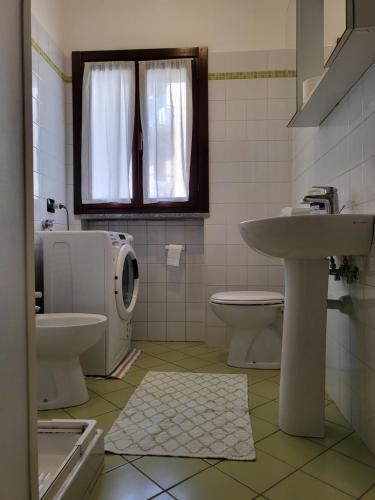 a bathroom with a sink and a toilet and a window at Dantino in Novara