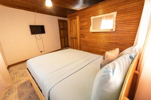 Un dormitorio pequeño con una cama y una ventana. en Tortugas Brews B&B formerly Cat in The Cup B&B, en Bocas Town