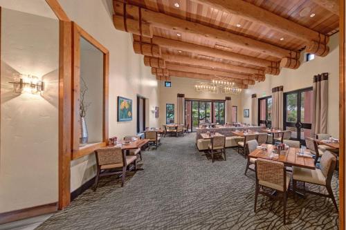 a restaurant with wooden ceilings and tables and chairs at Sheraton Grand at Wild Horse Pass in Chandler