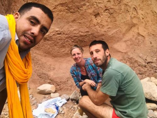 a group of three men sitting in front of a wall at Dar Mezyana Dades in Aït Idaïr