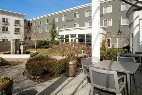 a patio with a table and chairs and a building at Courtyard by Marriott Seattle Kirkland in Kirkland