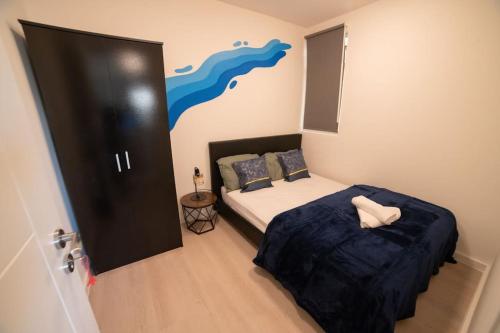 een slaapkamer met een bed met een blauwe deken bij Spacious and Stylish 1 Bed Modern Flat in Londen