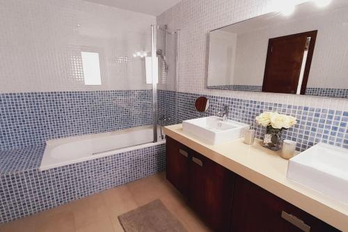 聖約瑟夫沙塔萊亞的住宿－Villa Ca Sa Roca en Sant Josep de sa Talaia，一间带水槽、浴缸和镜子的浴室