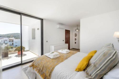 - une chambre avec un grand lit et une grande fenêtre dans l'établissement Villa Ca Sa Roca en Sant Josep de sa Talaia, à San José