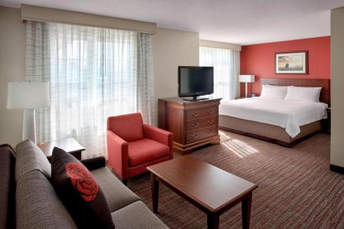 pokój hotelowy z łóżkiem, kanapą i telewizorem w obiekcie Residence Inn by Marriott Saratoga Springs w mieście Saratoga Springs