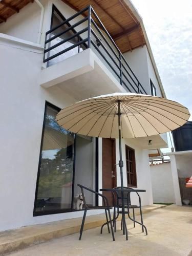 a table and chair with an umbrella in front of a house at Villa Paulina in Guadalupe