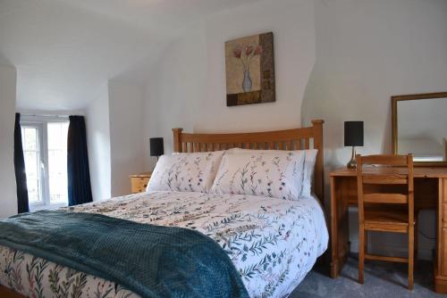 1 dormitorio con cama, escritorio y espejo en Windmill Cottage, en Little Eaton